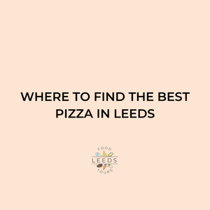 best pizza in Leeds: a single slice of pizza on a white paper plate, sat on a wooden table. The pizza is topped with cheese and tomato and the base is thin and crispy.